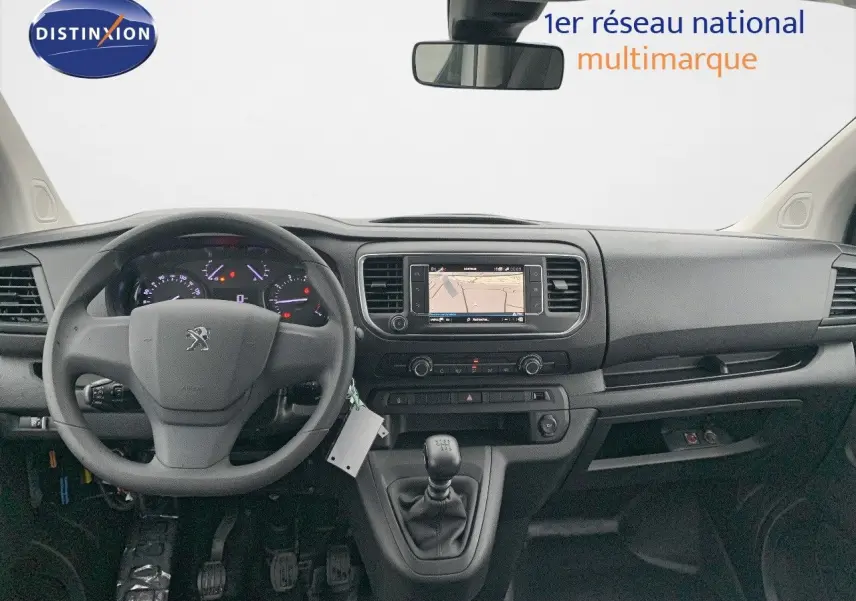 Vue intérieure frontale du tableau de bord noir du Peugeot Expert Cabine Approfondie blanc, avec volant, écran GPS et boîte manuelle.