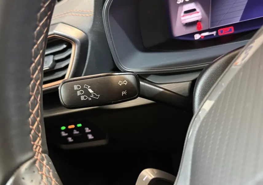 Gros plan sur la manette de clignotant noire à gauche du volant dans l'habitacle du CUPRA Formentor noir 2023.