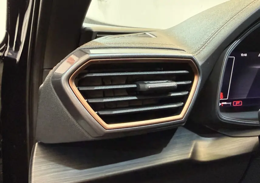 Gros plan sur la sortie d'air latérale droite du tableau de bord du CUPRA Formentor noir avec contour bronze.