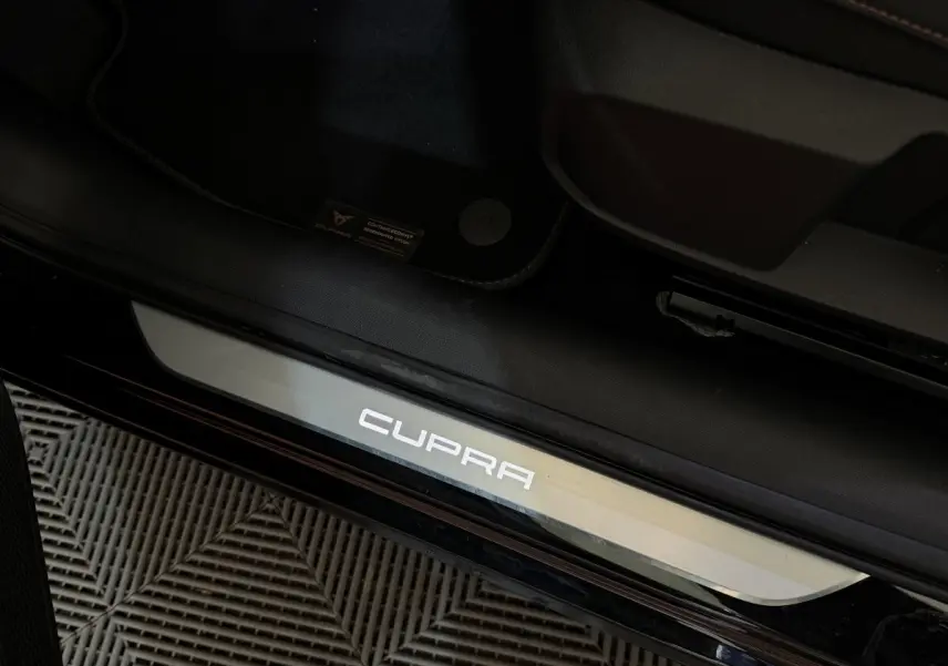 Gros plan sur le seuil de porte noir avec logo CUPRA lumineux du CUPRA Formentor 1.5 TSI 2023.