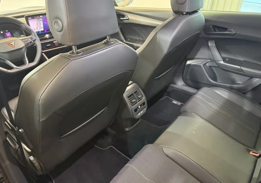 Intérieur arrière noir de la CUPRA Formentor 2023, vue depuis la banquette vers les sièges avant et tableau de bord.