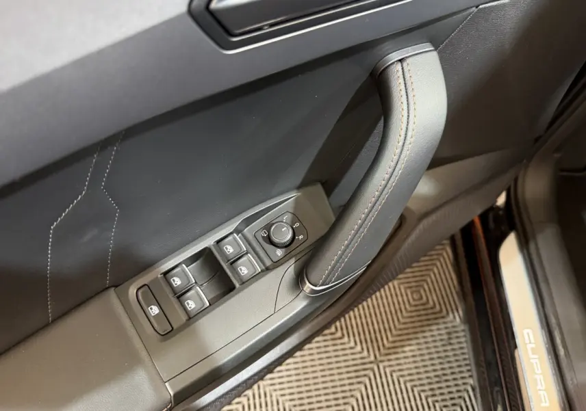 Poignée de porte côté gauche noir avec commandes vitres et rétroviseurs, seuil de porte CUPRA visible sur Formentor 2023.
