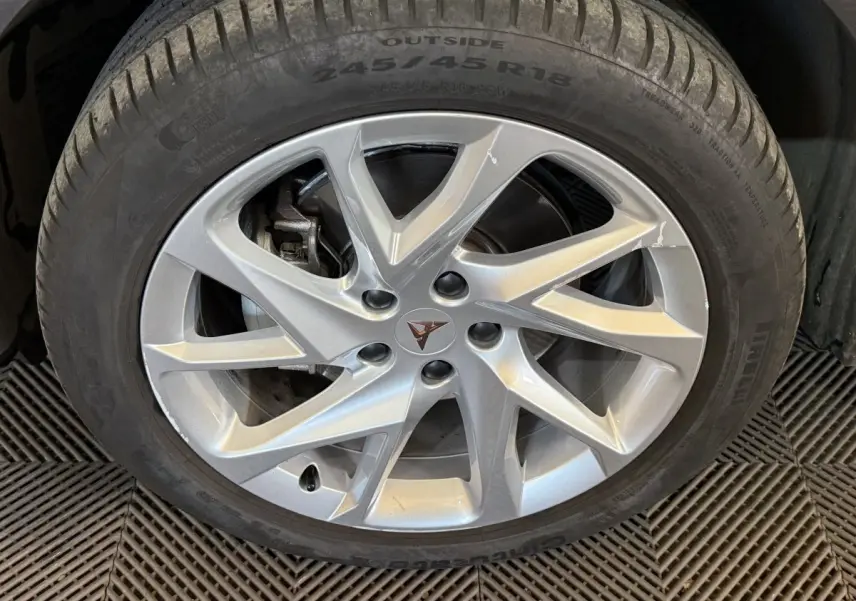 Gros plan sur la jante argentée à 5 doubles branches du CUPRA Formentor noir, mettant en valeur le logo central distinctif.