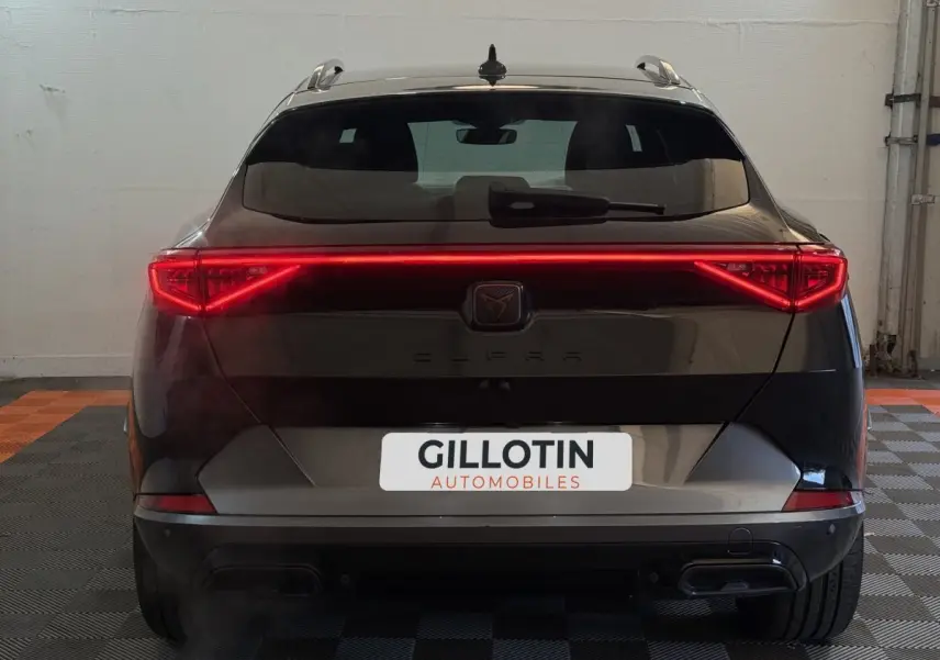 Vue arrière d'un CUPRA Formentor noir avec feux LED allumés et double sortie d'échappement visible.
