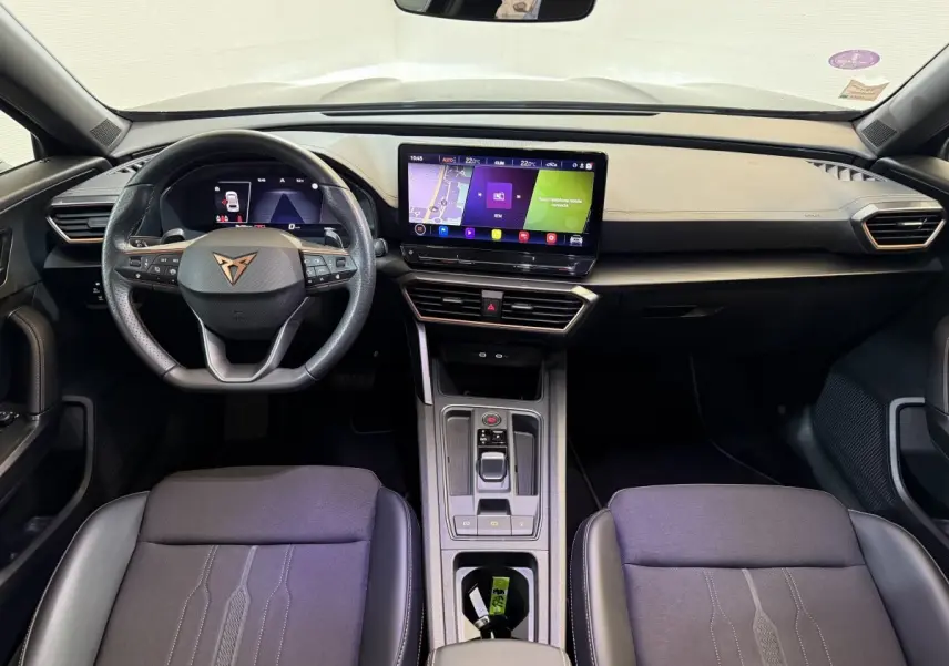 Intérieur de la CUPRA Formentor 2023 vu de face, tableau de bord noir avec écran tactile central et volant cuir.