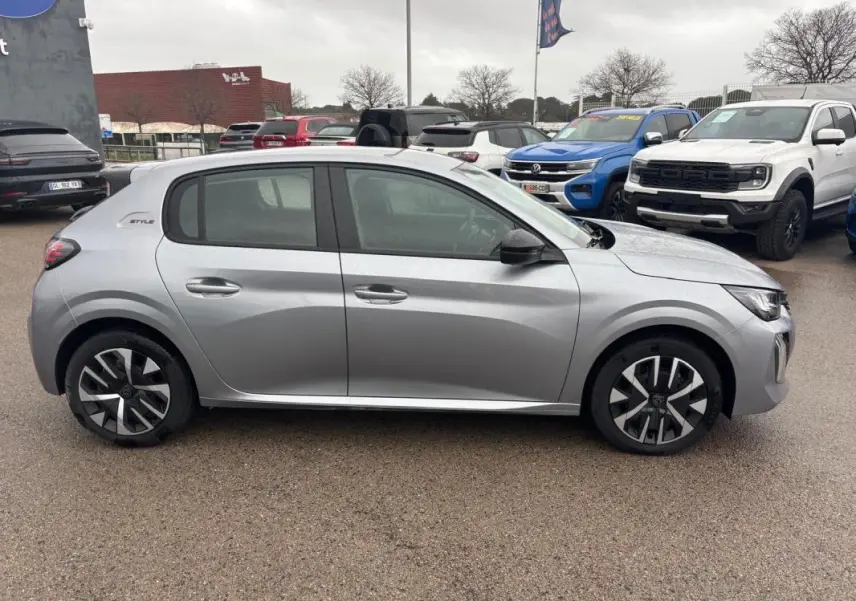 Vue latérale droite d'une Peugeot 208 Hybrid 100 e-DCS6 Style gris avec jantes 16 pouces et badge Style arrière.