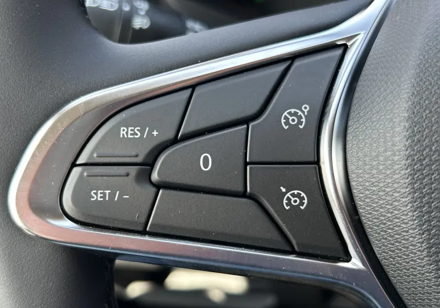 Gros plan sur les commandes de régulateur de vitesse au volant d’un Renault Trafic blanc, finition 2026.