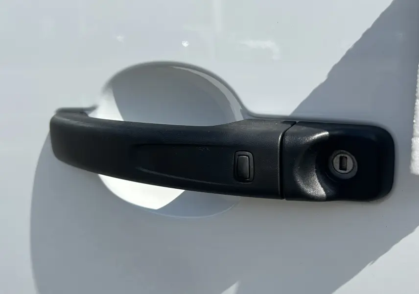 Poignée de porte noire en gros plan sur la porte blanche côté droit du Renault Trafic Cabine Approfondie L2H1 2026.