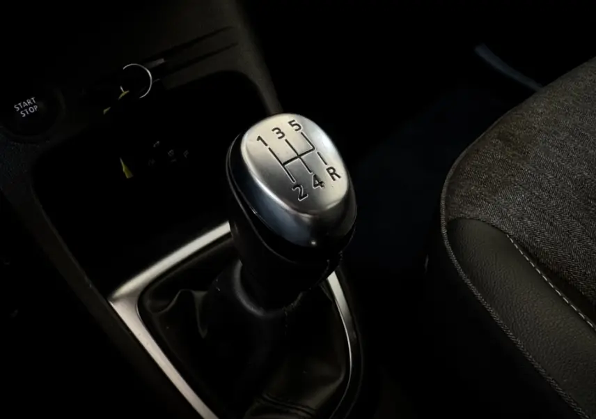 Gros plan sur le levier de vitesse manuel argenté du Renault Captur Intens 2019, siège tissu gris à côté.