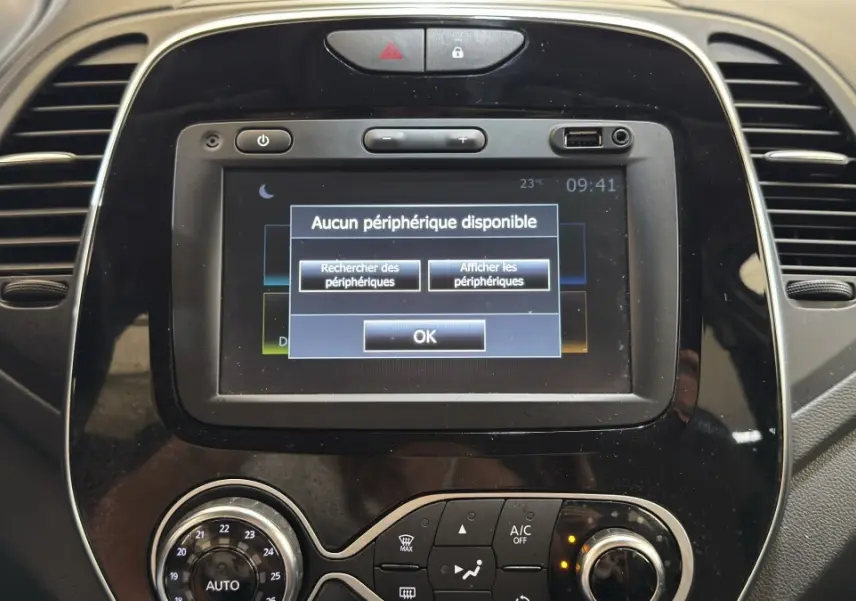 Gros plan sur l’écran tactile central noir du tableau de bord du Renault Captur blanc, affichant un message Bluetooth.