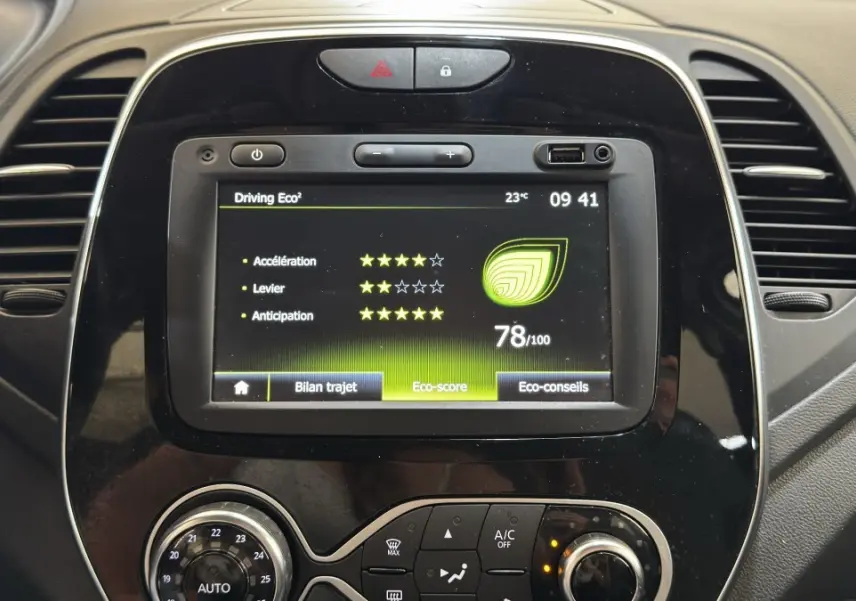 Vue rapprochée du tableau de bord noir du Renault Captur blanc 2019 avec écran tactile affichant l’éco-score.