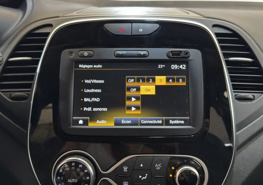 Vue rapprochée du tableau de bord noir du Renault Captur Intens TCe 90 avec écran tactile affichant les réglages audio.