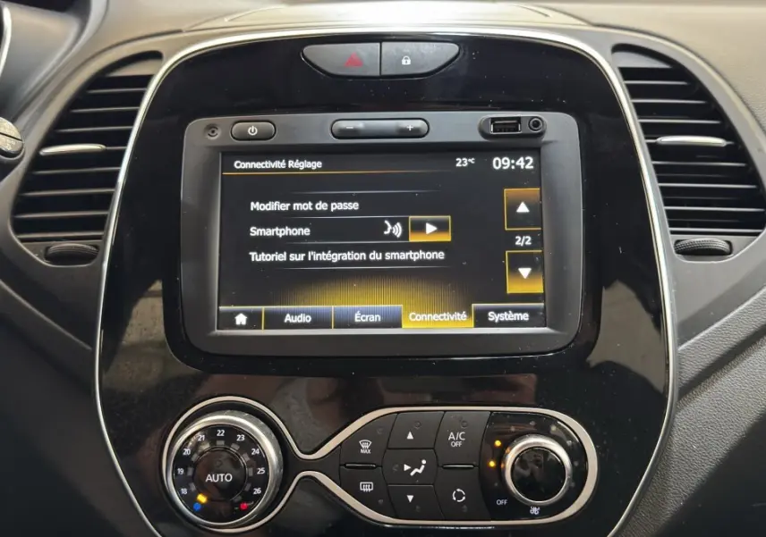 Vue rapprochée du tableau de bord noir du Renault Captur Intens 2019 avec écran tactile et commandes de climatisation.