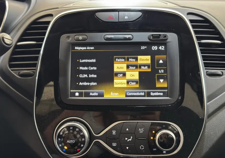 Vue rapprochée du tableau de bord noir du Renault Captur Intens 2019 avec écran tactile et commandes climatisation.