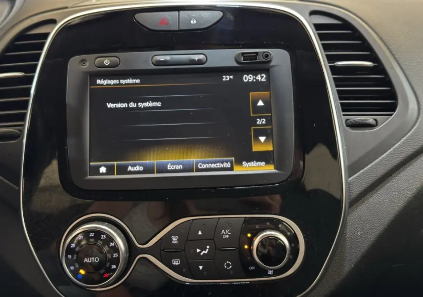 Gros plan sur l'écran tactile central et la console de climatisation du tableau de bord du Renault Captur blanc Intens TCe 90.