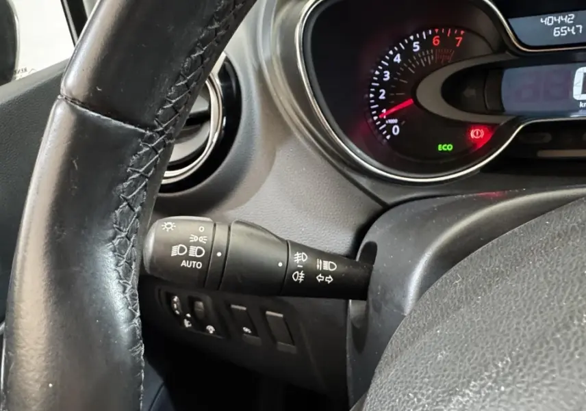Vue rapprochée du tableau de bord et du volant cuir noir du Renault Captur Intens TCe 90, avec commandes d’éclairage.