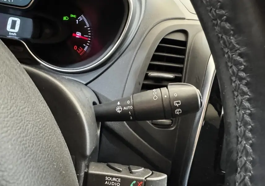 Gros plan intérieur sur le volant cuir noir et la commande d’essuie-glace du Renault Captur blanc Intens TCe 90 2019.