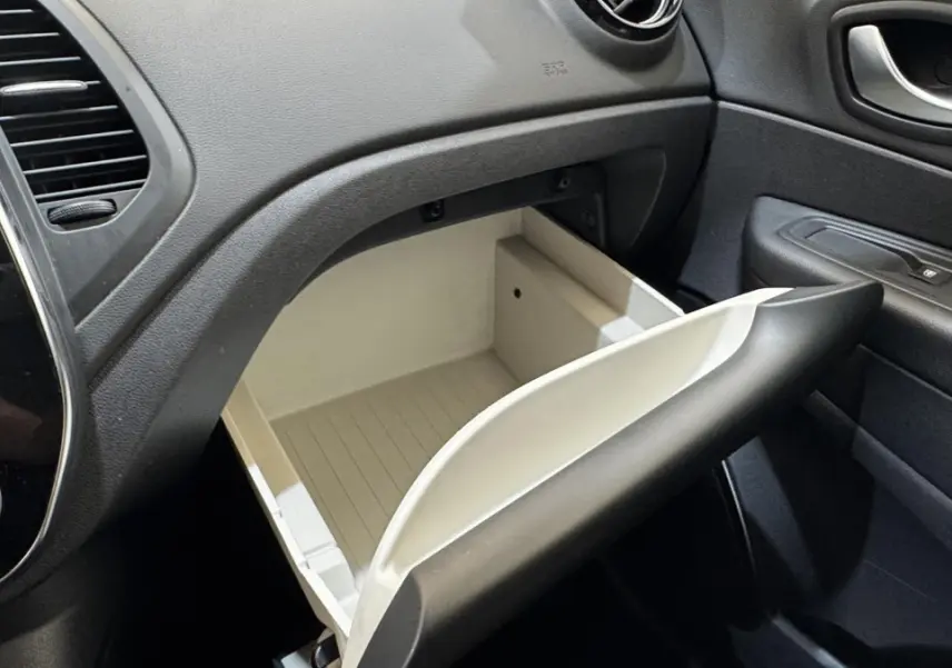 Vue intérieure du coffre à gants ouvert côté passager du Renault Captur Intens TCe 90, tableau de bord noir et garnitures sombres.