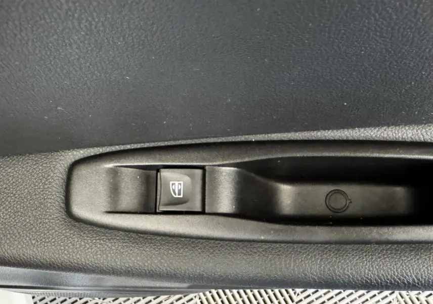 Gros plan sur le bouton de commande de la vitre électrique côté porte intérieure d’un Renault Captur blanc 2019.