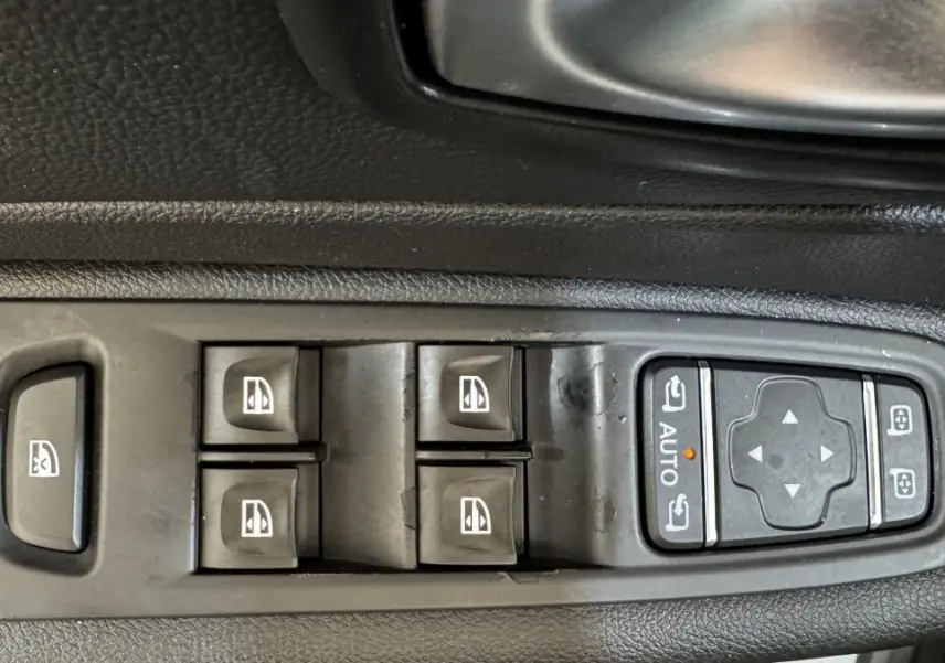 Gros plan sur les commandes des vitres et rétroviseurs côté conducteur d’un Renault Captur blanc 2019 Intens TCe 90.