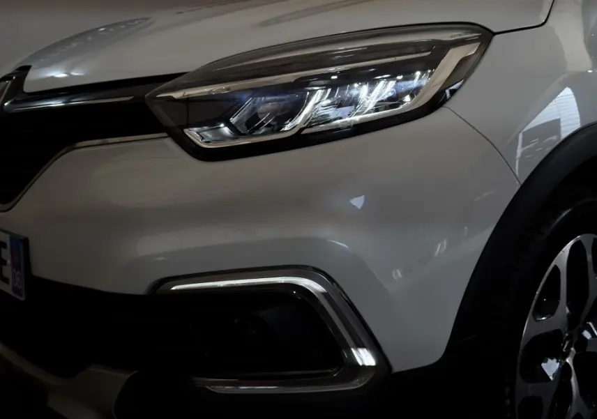 Gros plan sur l'avant droit blanc du Renault Captur Intens 2019, mettant en valeur le phare LED et la calandre.