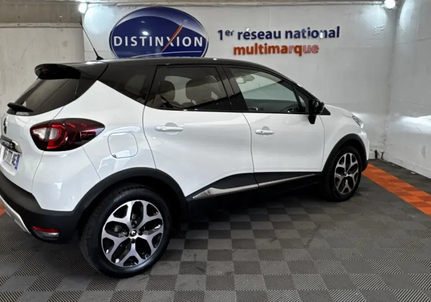 Renault Captur Intens blanc vu de profil droit, avec toit noir et jantes alliage distinctives.