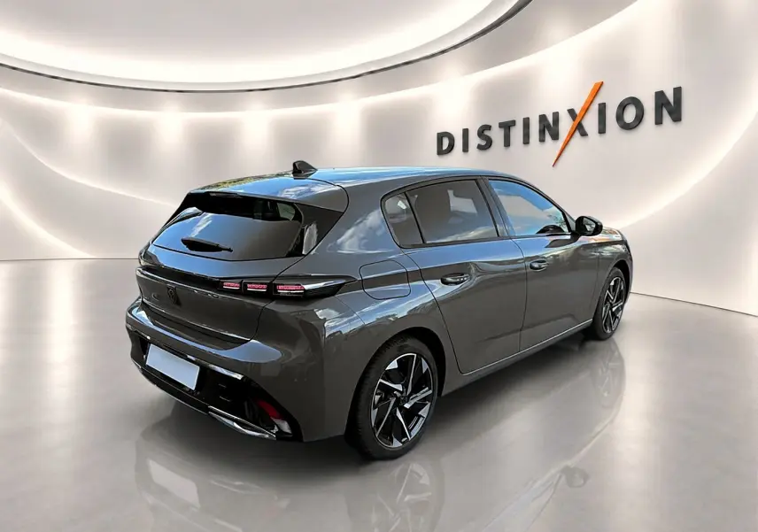 Peugeot 308 gris selenium vue 3/4 arrière droit dans un showroom avec jantes alliage noires et vitres surteintées.
