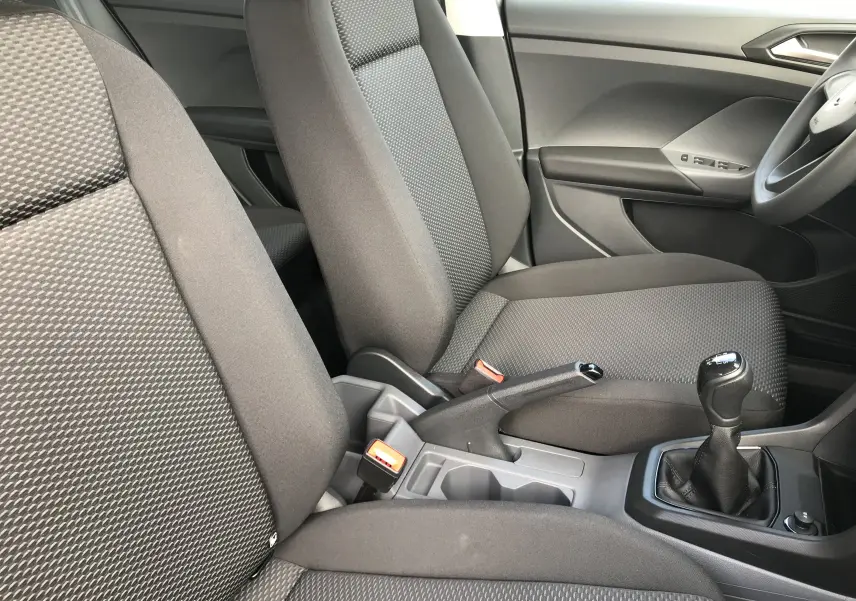 Intérieur avant du Volkswagen T-Cross 2020 avec sièges tissu noir et levier de vitesse manuel visible côté droit.