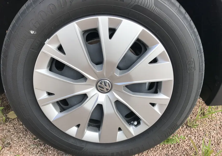 Gros plan sur la roue avant droite d'un Volkswagen T-Cross gris Limestone avec jante en alliage et pneu Goodyear.