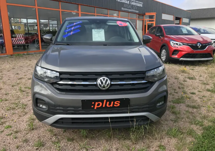 Vue avant d'un Volkswagen T-Cross 2020 gris limestone avec calandre noire et logo VW bien visible.