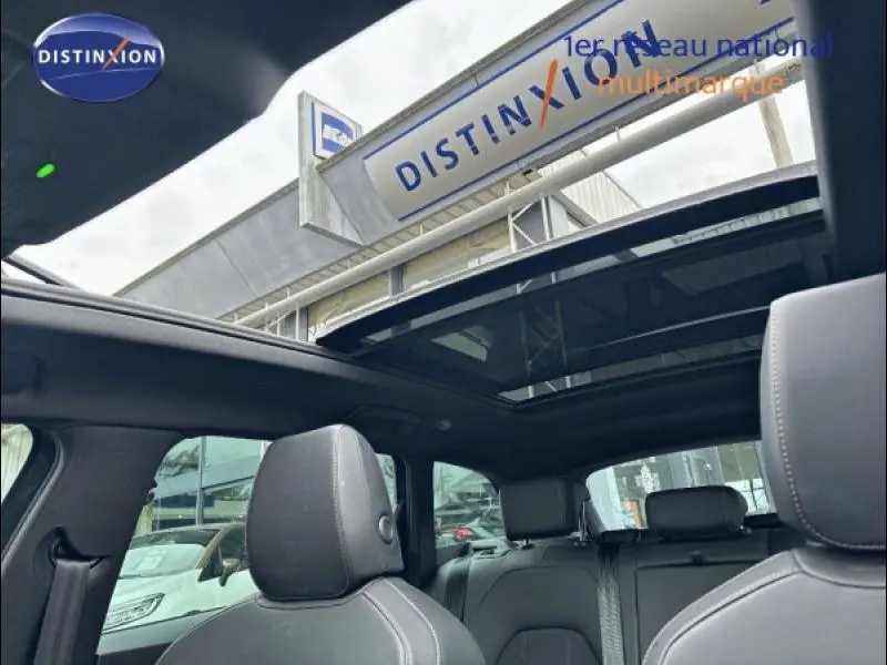 Vue intérieure du toit ouvrant panoramique et des sièges en tissu noir/similicuir de la CUPRA Leon 2024.