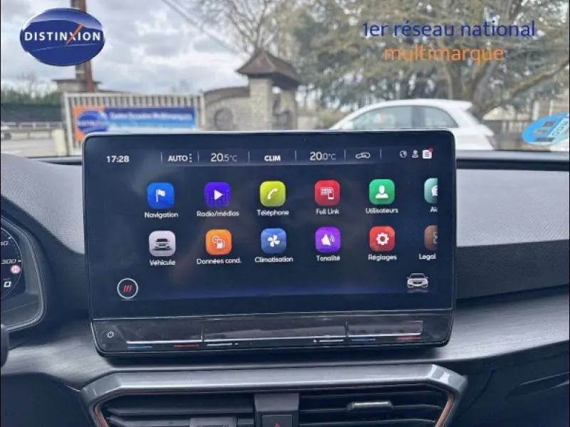 Écran tactile central du tableau de bord de la CUPRA Leon 1.5 eTSI 2024 avec interface colorée et commandes climatisation visibles.