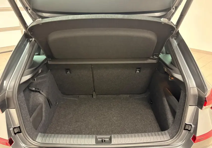 Coffre ouvert vu de l'arrière d'un Skoda Kamiq 2024 gris graphite, version Monte Carlo, montrant l'espace de chargement vide.