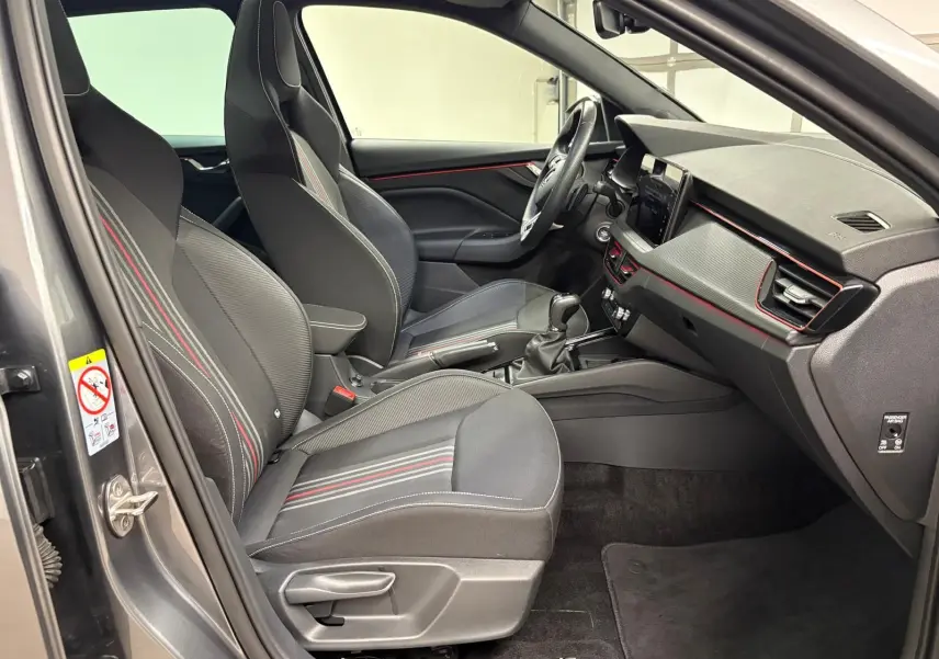 Vue intérieure côté conducteur du Skoda Kamiq 2024 gris graphite, avec sièges sport et détails rouges Monte Carlo.