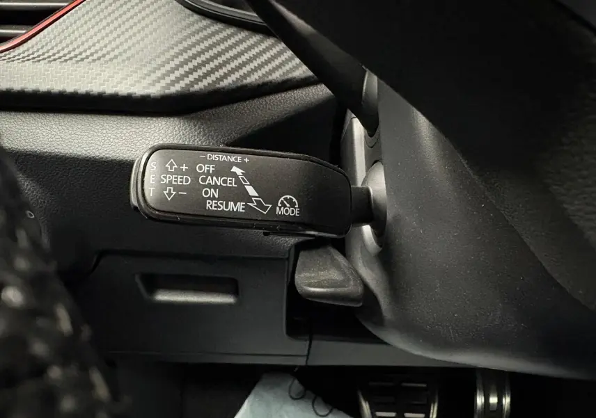 Gros plan sur la commande de régulateur de vitesse du Skoda Kamiq 1.5 TSI 150 DSG7 Monte Carlo gris graphite, intérieur noir.