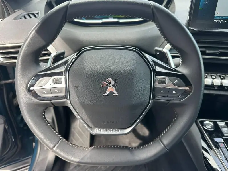 Vue rapprochée du volant cuir multifonction noir du Peugeot 3008 Hybride Rechargeable 2024 avec logo lion central argenté.