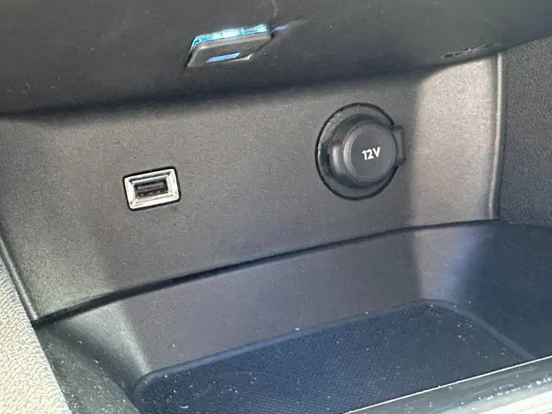 Prise 12V et port USB dans la console centrale noire du Peugeot 3008 Hybride Rechargeable 2024.