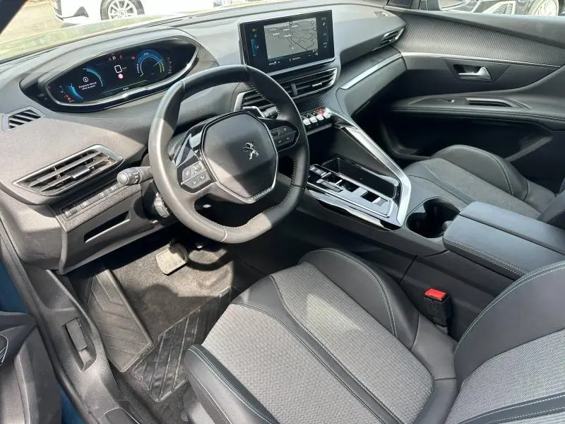 Vue intérieure côté conducteur du Peugeot 3008 Hybride Rechargeable 2024, montrant le volant cuir, tableau de bord digital et écran tactile central.