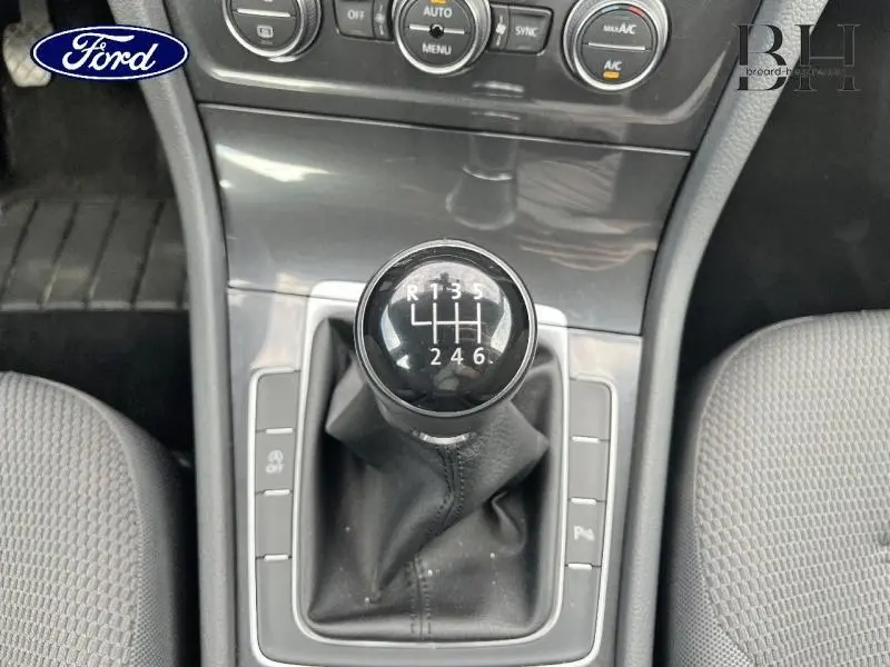 Gros plan sur le levier de vitesses manuel noir de la Volkswagen Golf SW, entouré de la console centrale grise.