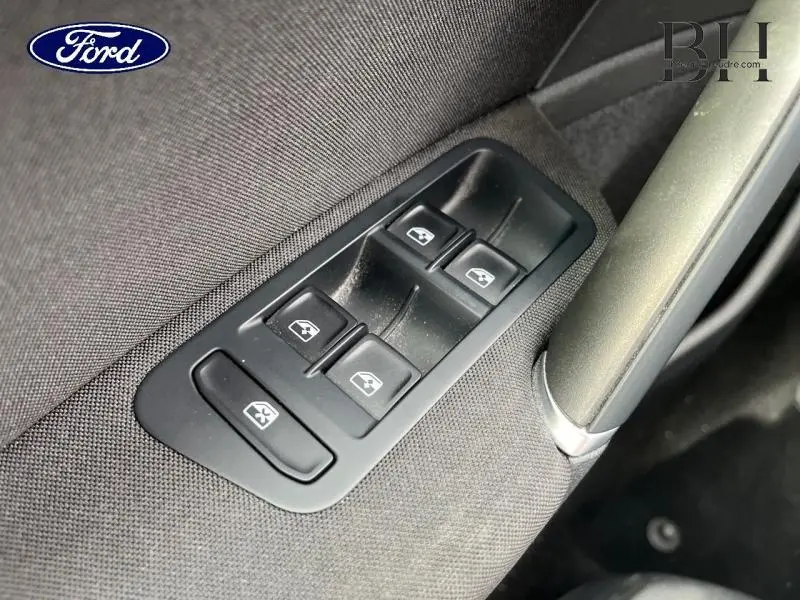 Gros plan sur les commandes des vitres électriques côté conducteur d'une Volkswagen Golf SW gris Tungsten, intérieur tissu.