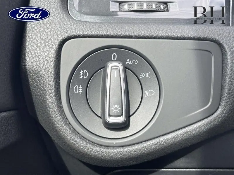 Gros plan sur la molette de réglage des phares dans l'habitacle d'une Volkswagen Golf SW gris Tungsten.