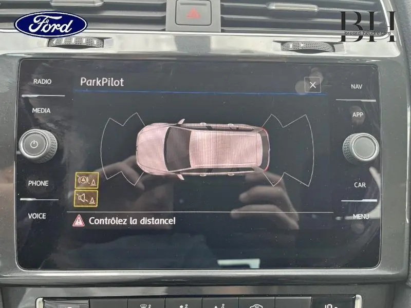 Écran tactile du système ParkPilot montrant une voiture vue de dessus avec alertes de distance active.