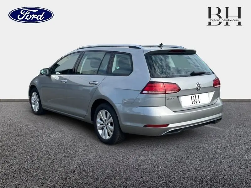 Volkswagen Golf SW gris Tungsten vue 3/4 arrière droit sur fond neutre avec feux arrière LED allumés.