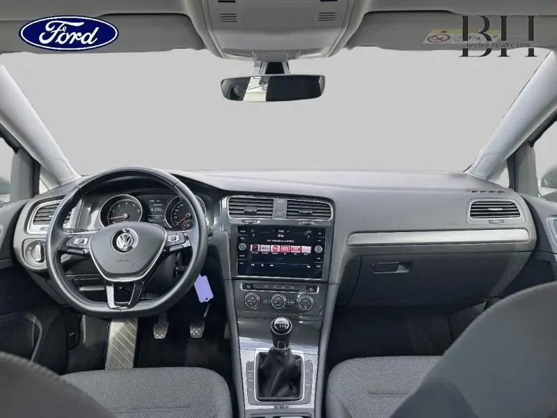 Vue intérieure avant du tableau de bord et volant cuir multifonction d’une Volkswagen Golf SW gris Tungsten de 2019 avec boîte manuelle.