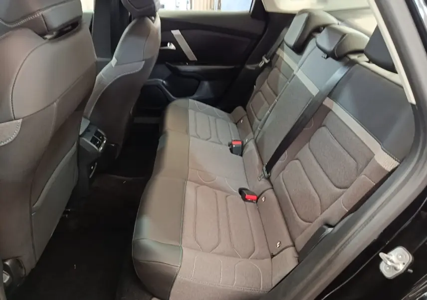Vue intérieure côté droit des sièges arrière gris et noir d'une Citroën C4 X noire, avec ceinture de sécurité visible.