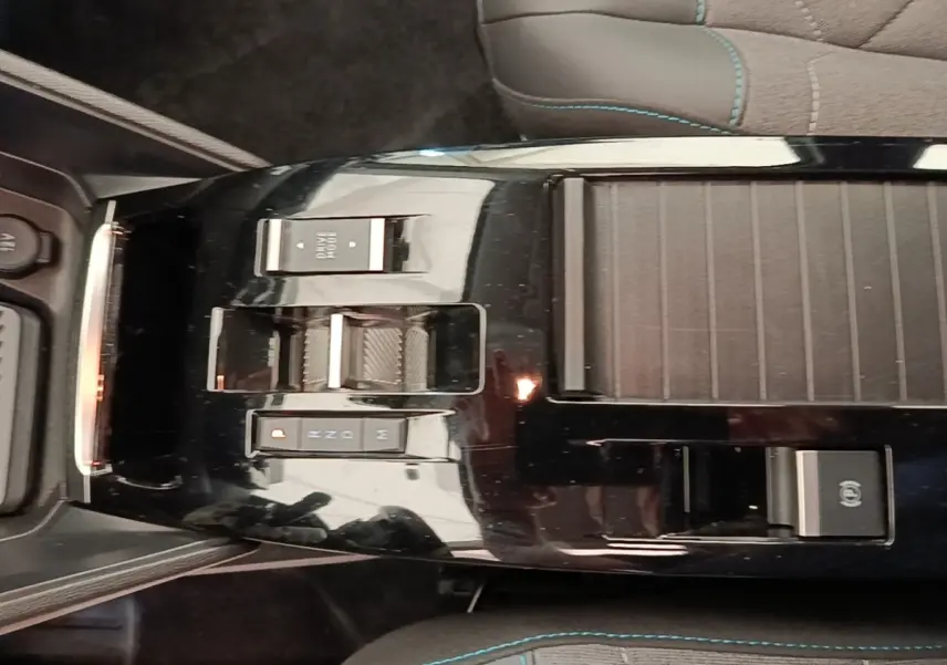 Vue plongeante sur la console centrale noire brillante de la Citroën C4 X avec commandes de boîte automatique et frein électrique.