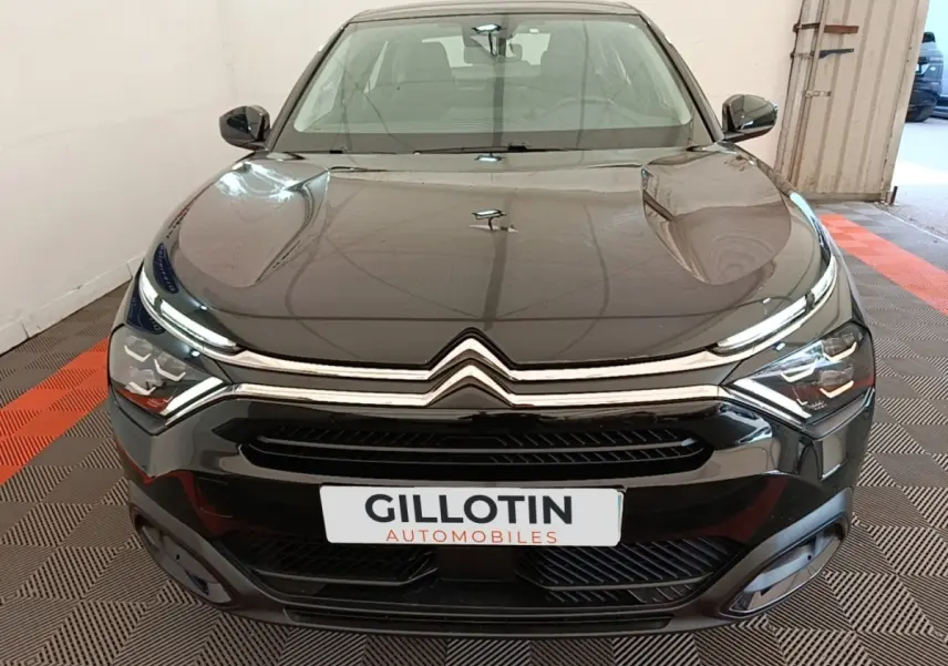 Vue avant d'une Citroën C4 X noire, mettant en valeur sa calandre chromée et ses phares LED distinctifs.