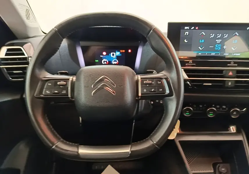 Vue intérieure centrée sur le volant cuir multifonctions noir et l'écran tactile du tableau de bord de la Citroën C4 X 2023.