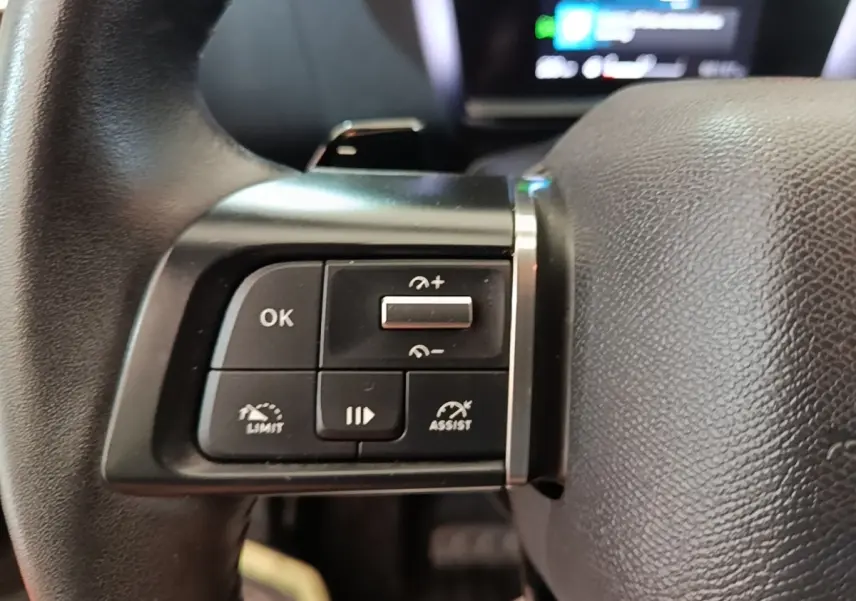 Gros plan sur les commandes multifonctions du volant cuir de la Citroën C4 X PureTech 130 noir, 2023.