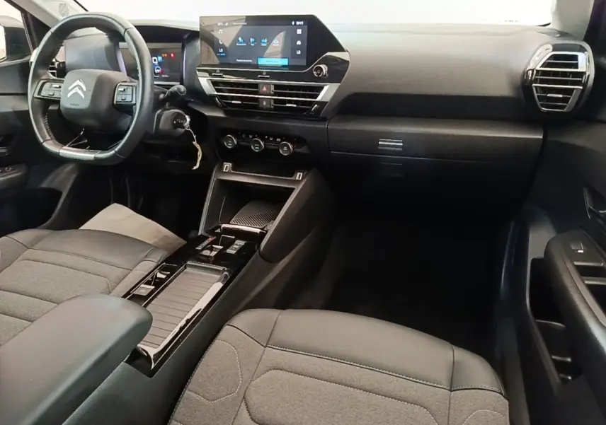 Intérieur noir de la Citroën C4 X 2023, vue de face côté conducteur avec tableau de bord et écran tactile central.